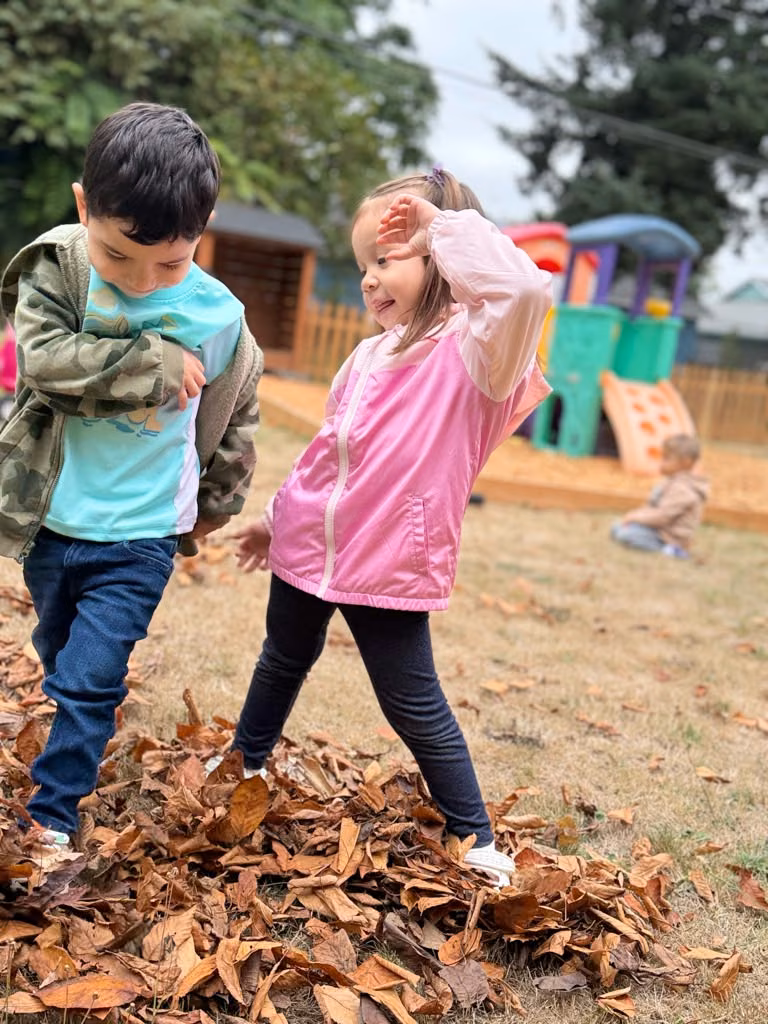 Niños jugando entre las hojas de otoño