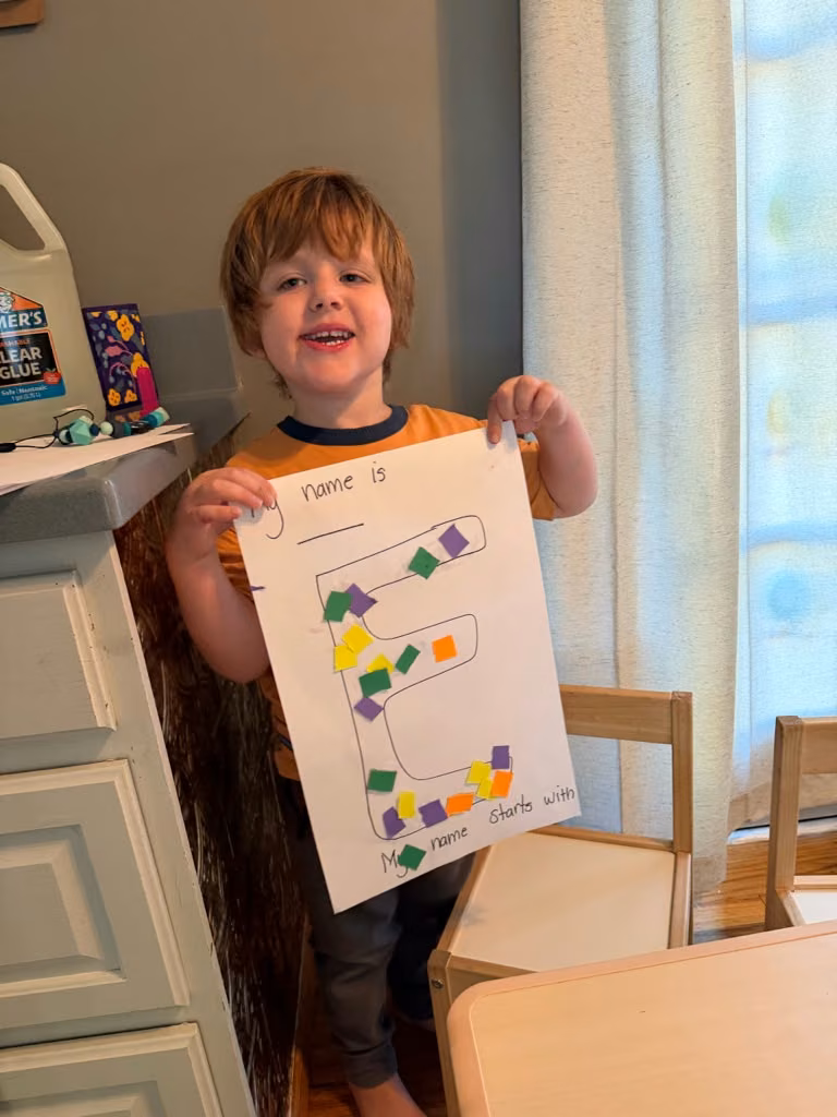 Niño mostrando su trabajo de formas y colores