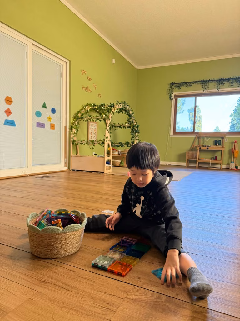 Niño explorando materiales educativos en el salón