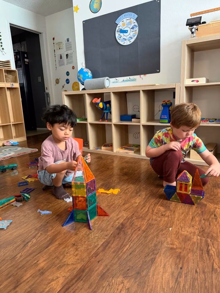 Niños construyendo con bloques magnéticos en el salón