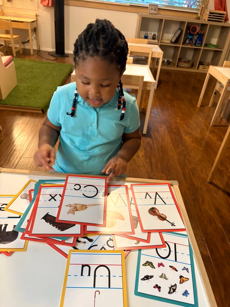 Niña explorando tarjetas del abecedario