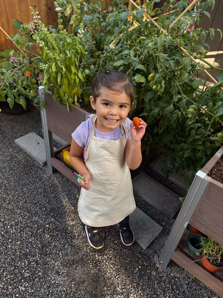 Niña en el huerto con su delantal de jardinería
